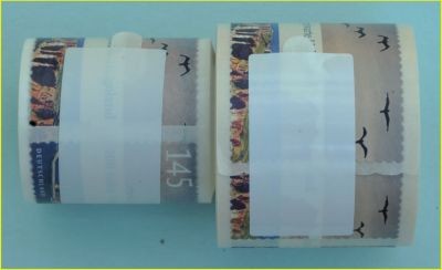 Rollenvergleich Helgolandmarke selbstklebend mit dem Verschlussaufkleber – rechts die echte Marke mit dem größeren Rollendurchmesser, links die falsche Marke die wesentlich enger gerollt ist Rollenvergleich Helgolandmarke selbstklebend mit dem Verschlussaufkleber – rechts die echte Marke mit dem größeren Rollendurchmesser, links die falsche Marke die wesentlich enger gerollt ist